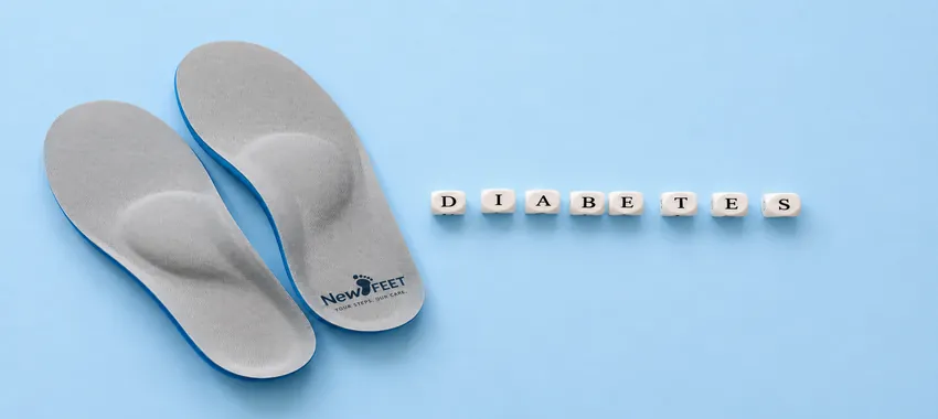 Diabetic orthotic insoles on a light blue background with diabetes letter blocks